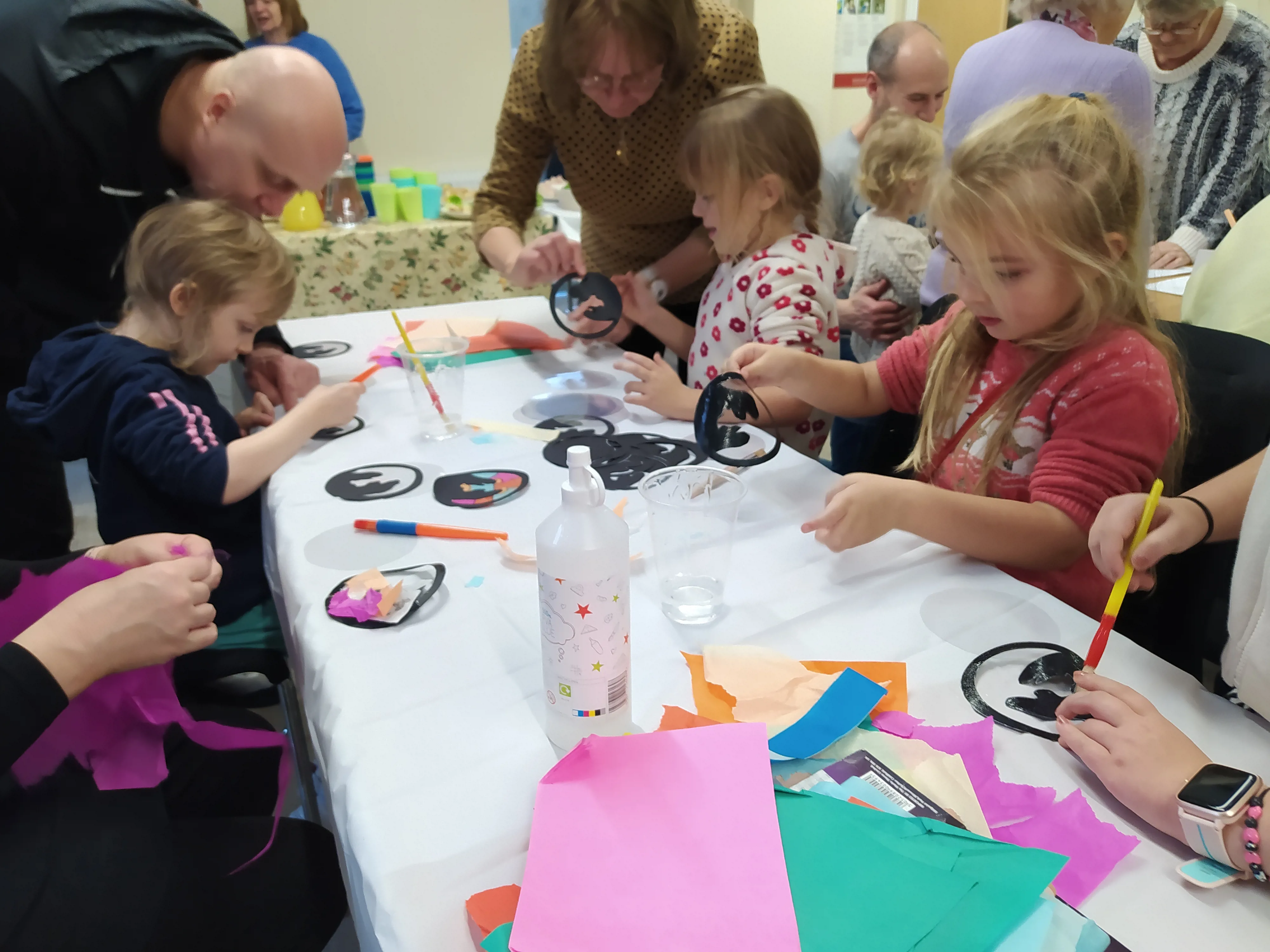 Children doing craft activity with adults helping them.