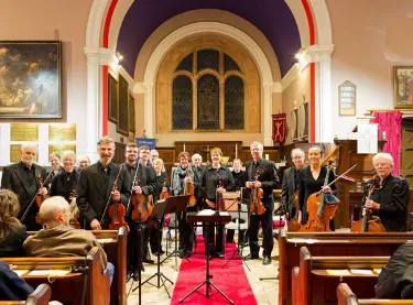 Vale Royal Springs Group in church facing audience with instruments in hand